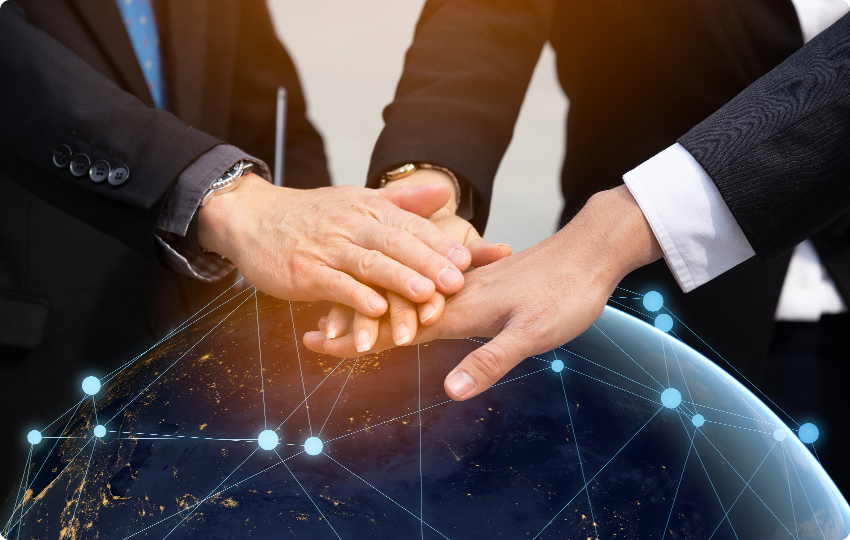 Hands joined over a connected globe — collaboration